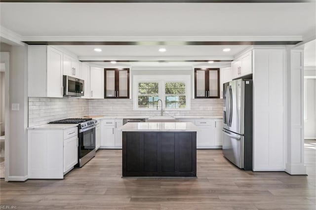 kitchen featuring a sink, decorative backsplash, ornamental molding, and stainless steel appliances