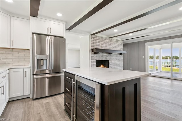 kitchen with stainless steel fridge, light wood-style floors, open floor plan, wine cooler, and beamed ceiling