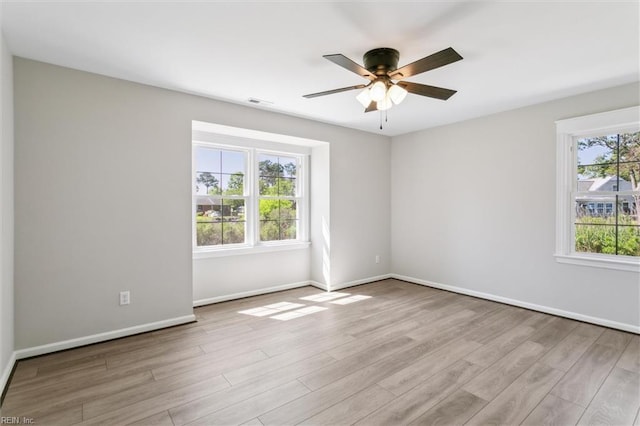 empty room featuring baseboards, ceiling fan, and wood finished floors