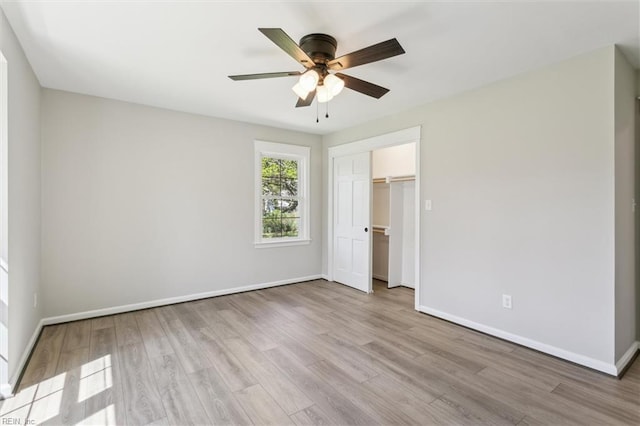 unfurnished bedroom with baseboards, a ceiling fan, wood finished floors, and a closet