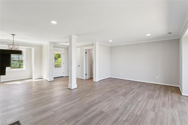 unfurnished living room featuring crown molding, ornate columns, baseboards, and wood finished floors