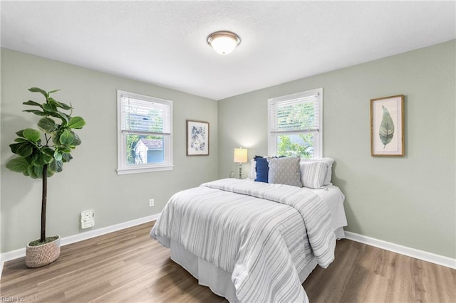 bedroom featuring baseboards and wood finished floors