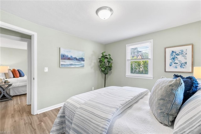 bedroom featuring baseboards and light wood-style floors