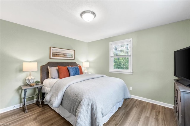 bedroom featuring baseboards and wood finished floors