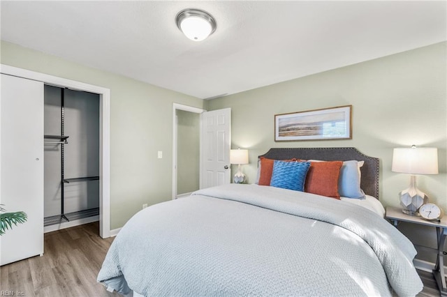 bedroom with baseboards, a closet, and wood finished floors