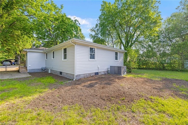 view of side of home with fence, cooling unit, and crawl space