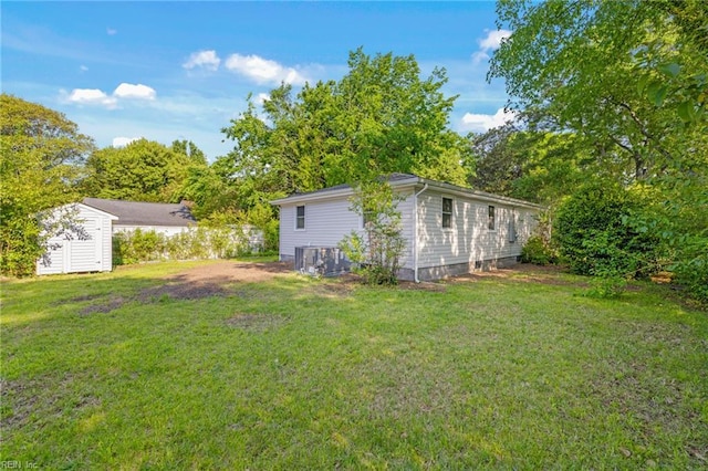 view of yard featuring a storage shed, central AC unit, and an outdoor structure
