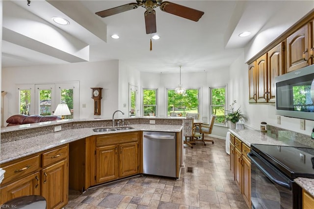 kitchen featuring brown cabinetry, ceiling fan, recessed lighting, a sink, and stainless steel appliances