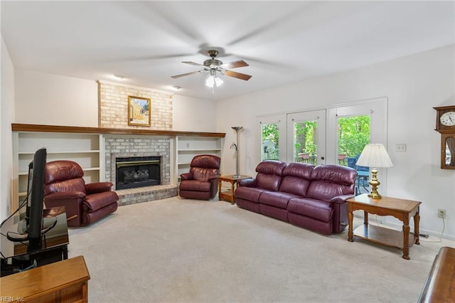 living area with carpet flooring, a ceiling fan, baseboards, and a brick fireplace