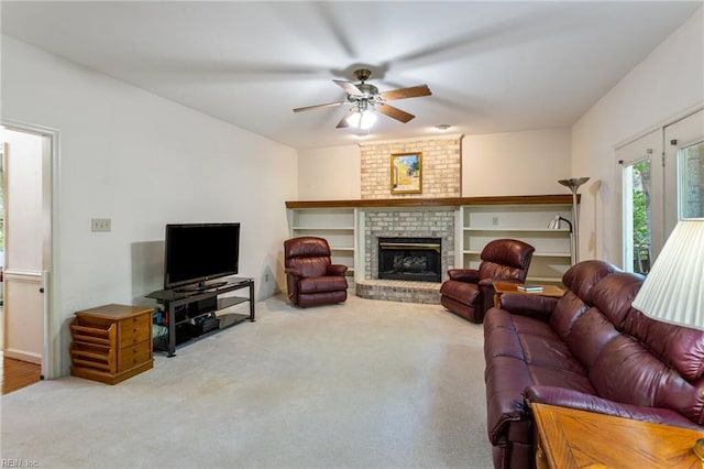 carpeted living area featuring a brick fireplace and ceiling fan