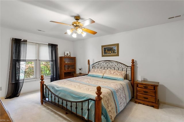 bedroom with a ceiling fan, visible vents, and light carpet
