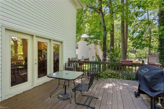 deck featuring outdoor dining space and a grill