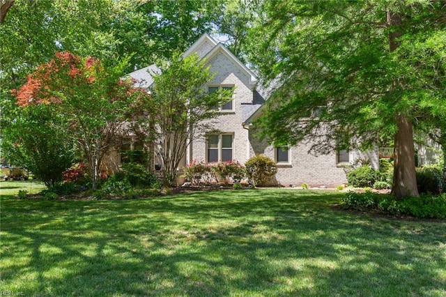 view of front facade featuring brick siding and a front lawn