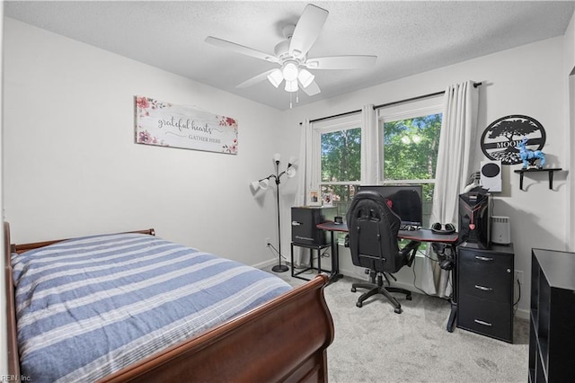 carpeted bedroom with a textured ceiling, ceiling fan, and baseboards