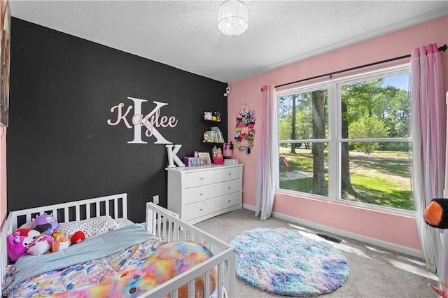 bedroom featuring baseboards, carpet flooring, a textured ceiling, and visible vents
