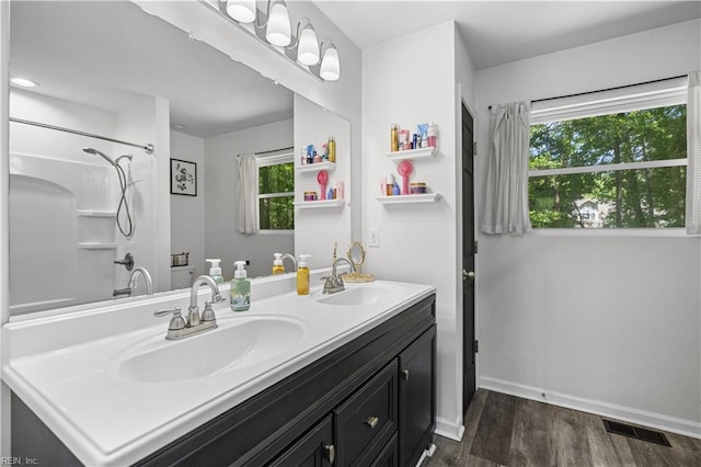 full bath featuring visible vents, a sink, baseboards, and wood finished floors