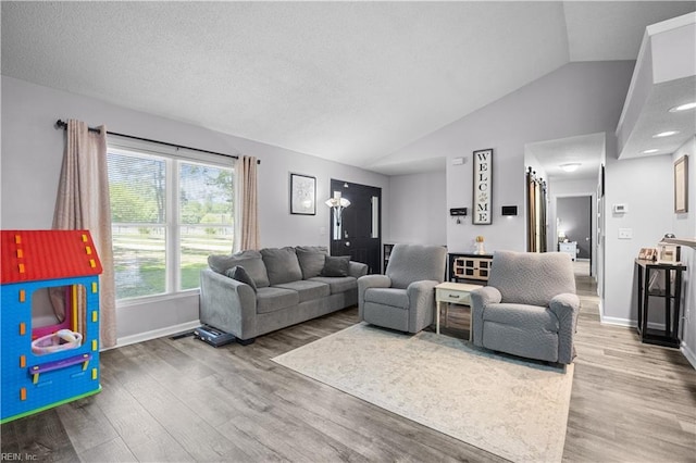 living area featuring baseboards, wood finished floors, and vaulted ceiling