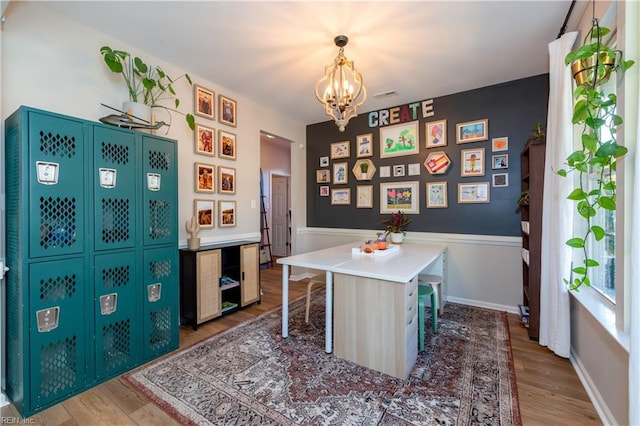office space with visible vents, an inviting chandelier, and light wood finished floors