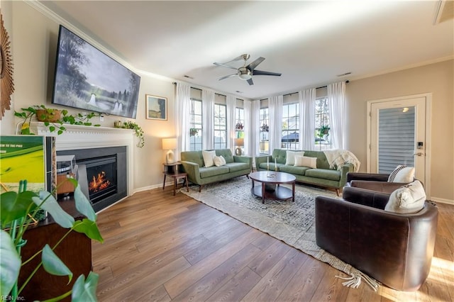 living area featuring crown molding, a ceiling fan, and wood finished floors