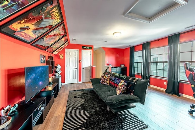 living area with baseboards, attic access, wood finished floors, and visible vents