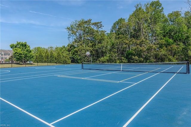 view of tennis court with fence and community basketball court