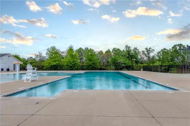 community pool with fence and a patio area