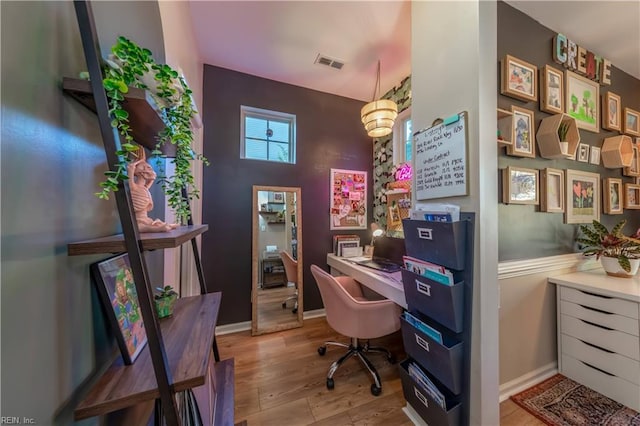 office area featuring visible vents, baseboards, and wood finished floors