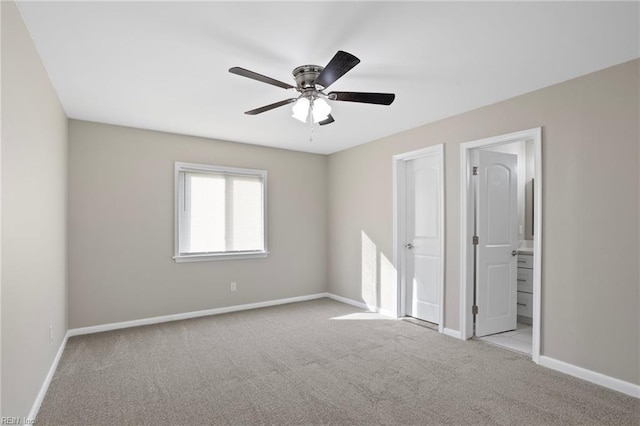 unfurnished bedroom with carpet floors, baseboards, ceiling fan, and connected bathroom