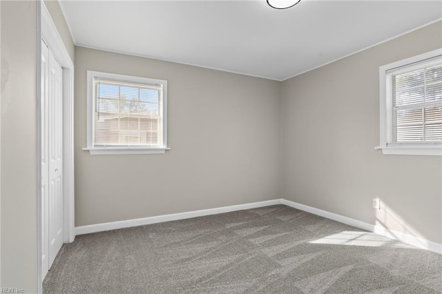 empty room featuring carpet floors and baseboards