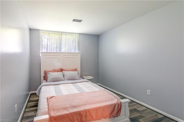 bedroom featuring baseboards, dark wood finished floors, and visible vents