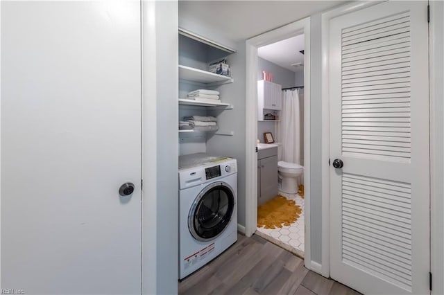 laundry room featuring laundry area, washer / dryer, and wood finished floors