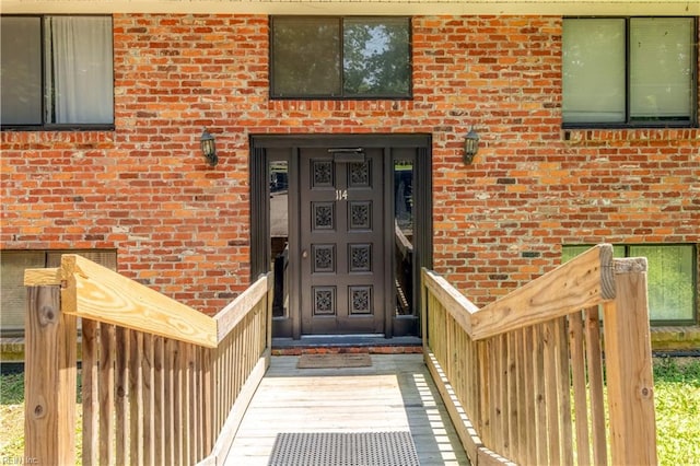 doorway to property featuring brick siding