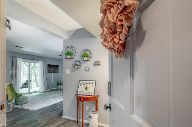 corridor featuring baseboards and wood finished floors