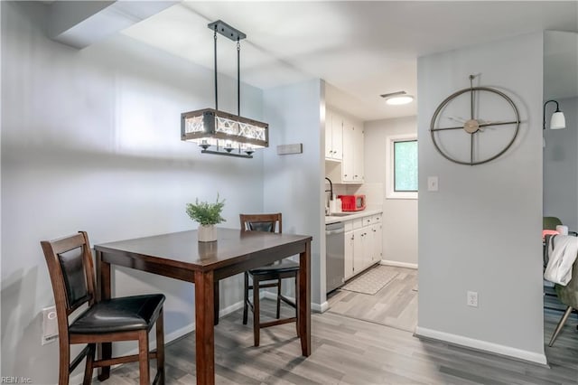 dining room featuring baseboards and light wood-type flooring