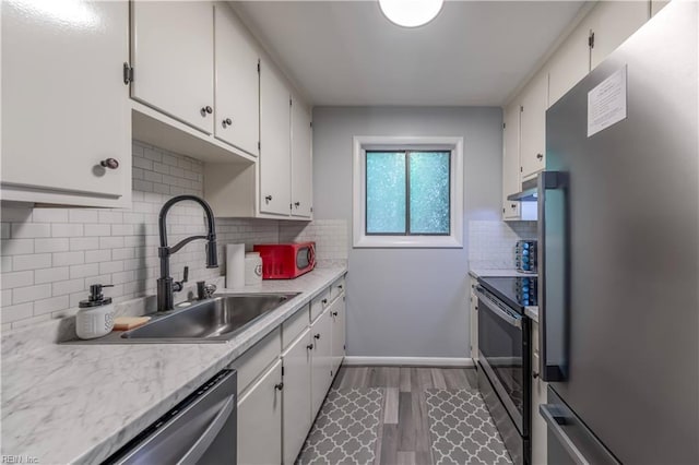 kitchen with light countertops, under cabinet range hood, tasteful backsplash, and stainless steel appliances