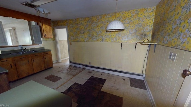 1233 Transylvania Ave, Chesapeake, VA 23324 - kitchen with a baseboard heating unit, wallpapered walls, a wainscoted wall, a sink, and brown cabinets