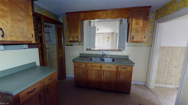 1233 Transylvania Ave, Chesapeake, VA 23324 - kitchen featuring a sink, brown cabinetry, wallpapered walls, and baseboards
