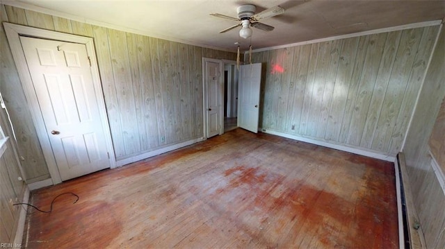 1233 Transylvania Ave, Chesapeake, VA 23324 - unfurnished bedroom featuring wood finished floors, baseboard heating, baseboards, wood walls, and ceiling fan