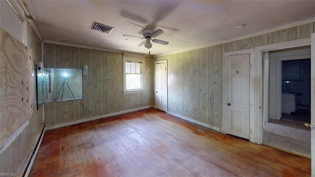 1233 Transylvania Ave, Chesapeake, VA 23324 - unfurnished bedroom with wood finished floors, baseboard heating, wooden walls, crown molding, and a closet