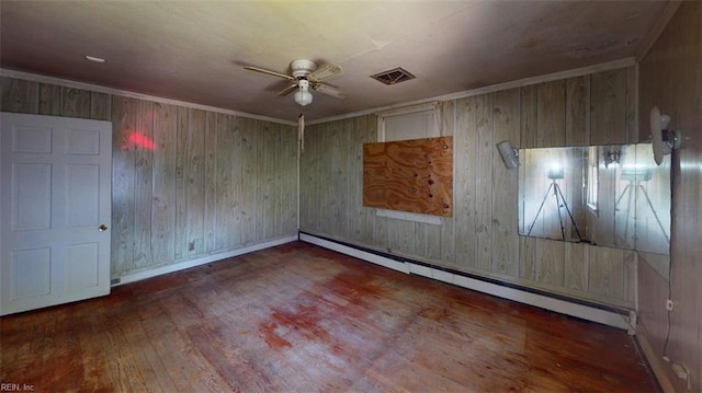 1233 Transylvania Ave, Chesapeake, VA 23324 - spare room with a ceiling fan, wood finished floors, baseboard heating, wooden walls, and baseboards