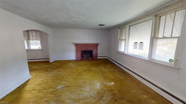 1233 Transylvania Ave, Chesapeake, VA 23324 - unfurnished living room featuring a baseboard radiator, a fireplace, arched walkways, and baseboards