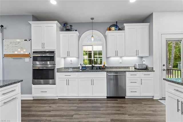 kitchen with a sink, appliances with stainless steel finishes, white cabinets, and a wealth of natural light