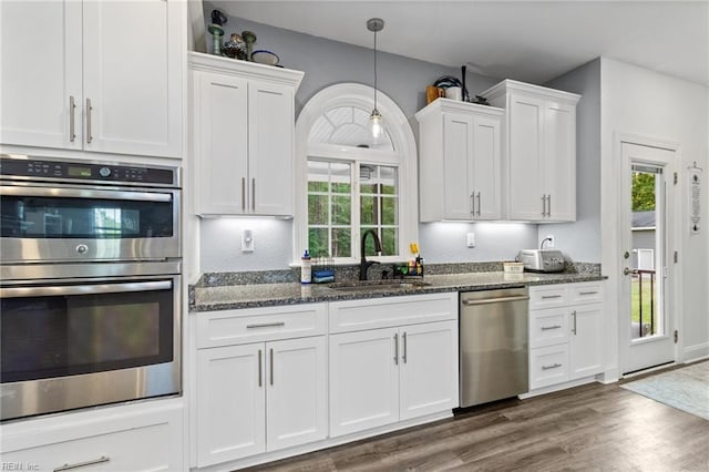 kitchen featuring a sink, appliances with stainless steel finishes, white cabinets, and dark wood-style floors