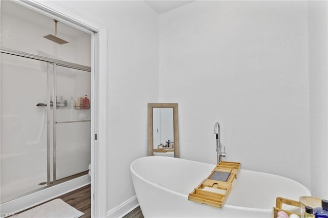 bathroom featuring a soaking tub, a stall shower, wood finished floors, and visible vents