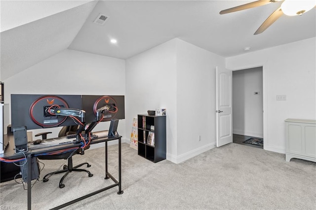 carpeted office space featuring baseboards, ceiling fan, lofted ceiling, and visible vents