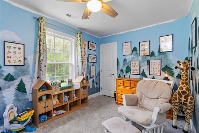 sitting room featuring ceiling fan, visible vents, baseboards, ornamental molding, and carpet