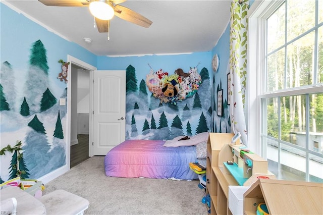 carpeted bedroom featuring a ceiling fan and multiple windows