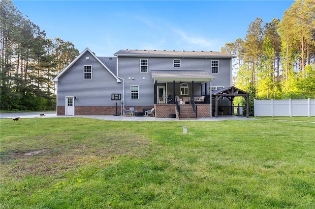 rear view of house featuring a yard, a patio, a gazebo, and fence