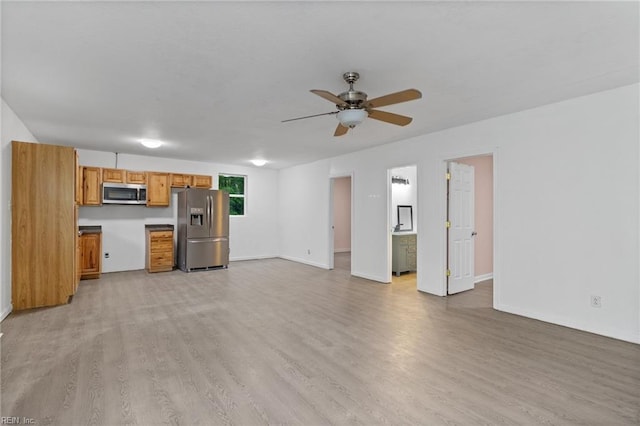 unfurnished living room featuring baseboards, a ceiling fan, and light wood-style flooring