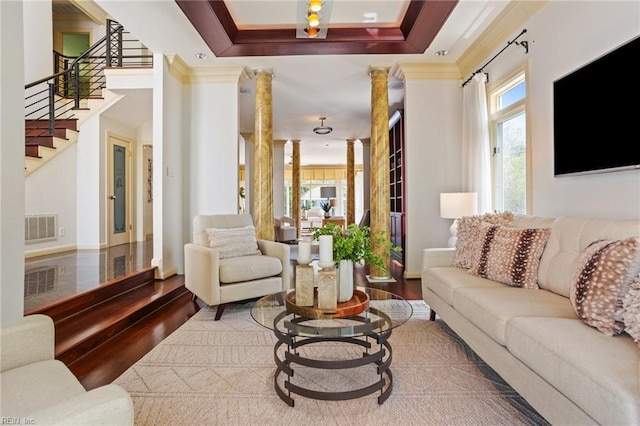 living area with crown molding, stairs, decorative columns, wood finished floors, and visible vents